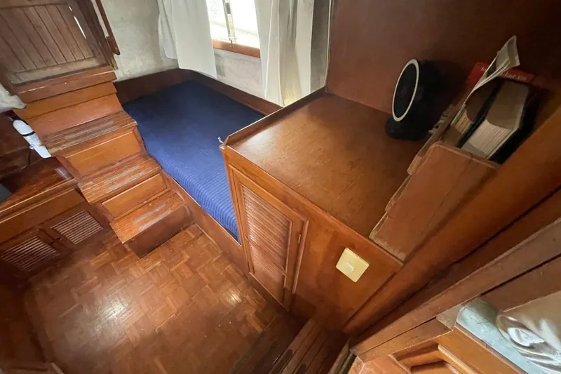 Slide: The Image of 1991 Marine Trader 34 Double Cabin interior with wooden cabinetry and blue bedding. - 29