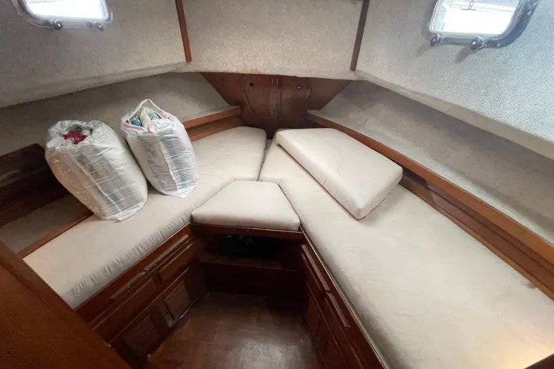 Slide: The Image of 1991 Marine Trader 34 Double Cabin interior with beige cushions and storage bags. - 3