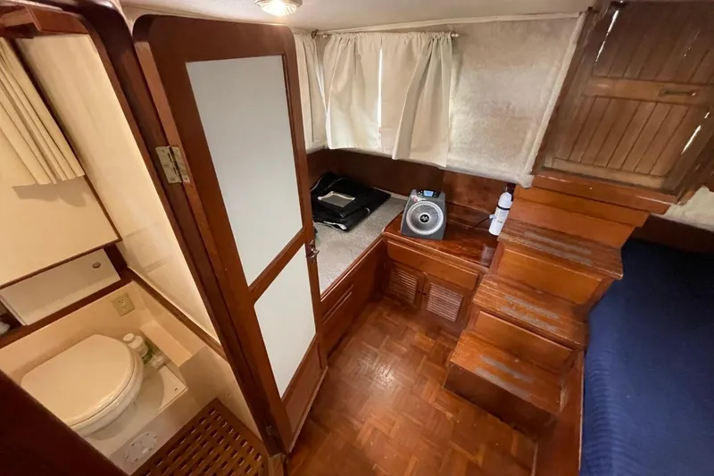 Slide: The Image of 1991 Marine Trader 34 Double Cabin interior with wooden stairs and compact bathroom. - 31