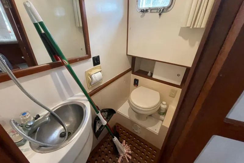 Slide: The Image of Bathroom of 1991 Marine Trader 34 Double Cabin with sink, toilet, and cleaning supplies. - 32
