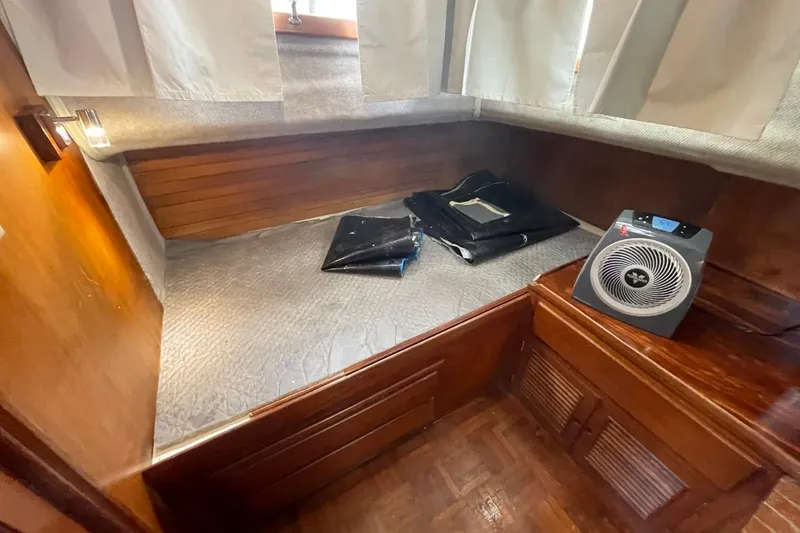 Slide: The Image of 1991 Marine Trader 34 Double Cabin interior with wooden finish and portable fan. - 33