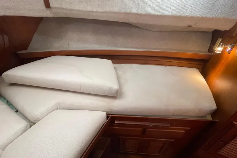 Slide: The Image of 1991 Marine Trader 34 Double Cabin interior with cushioned berth and wooden accents. - 4
