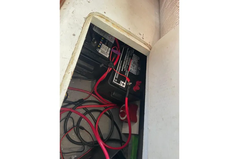 Slide: The Image of Battery compartment of 1991 Marine Trader 34 Double Cabin with red and black cables. - 42