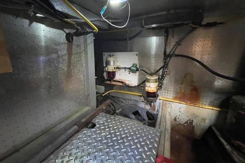 Slide: The Image of Engine room of 1991 Marine Trader 34 Double Cabin with fuel filters and metal flooring. - 45