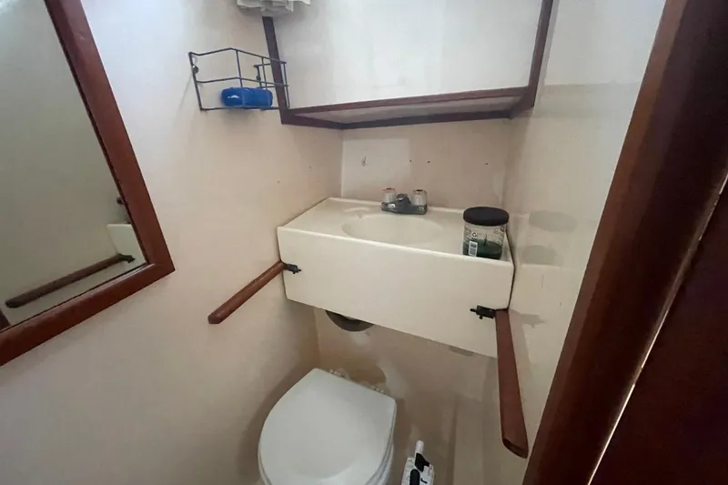 Slide: The Image of 1991 Marine Trader 34 Double Cabin bathroom with sink, mirror, and toilet. - 5