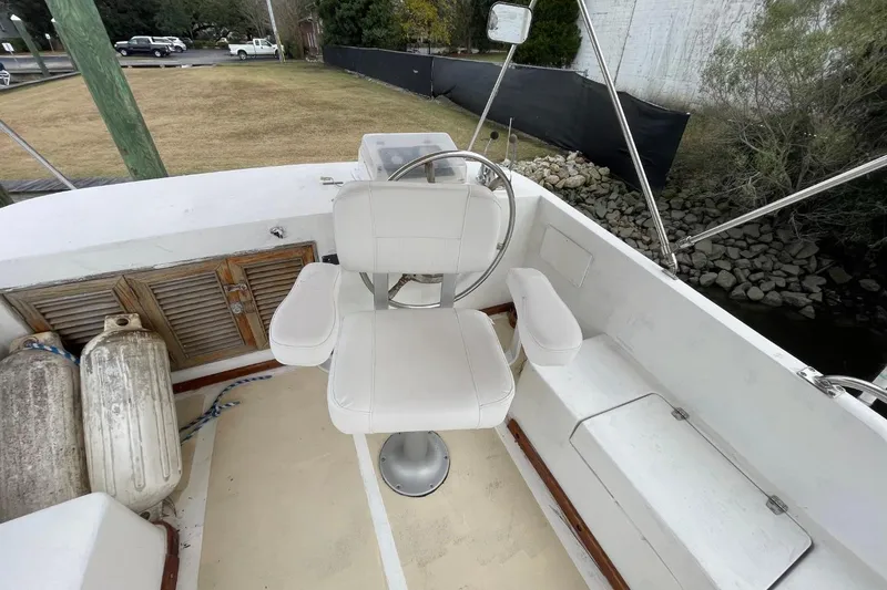 Slide: The Image of 1991 Marine Trader 34 Double Cabin helm with white captain's chair and outdoor view. - 50