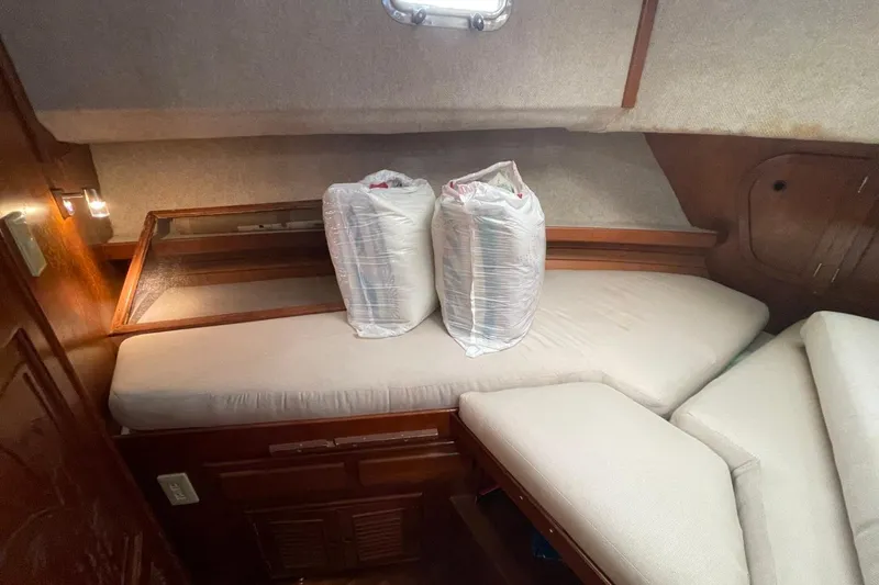 Slide: The Image of 1991 Marine Trader 34 Double Cabin interior with cushioned seating and storage bags. - 6