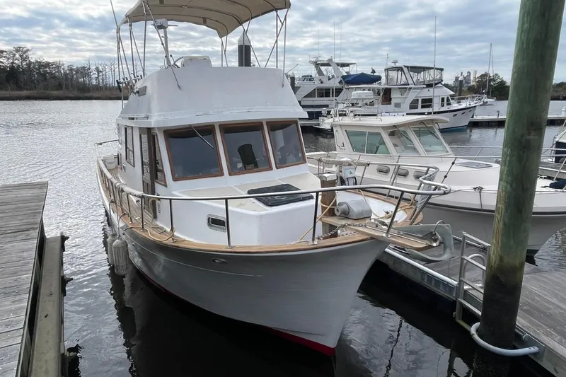 Slide: The Image of 1991 Marine Trader 34 Double Cabin docked at a marina under cloudy skies. - 62