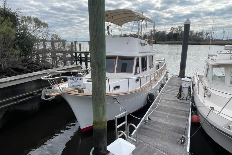 Slide: The Image of 1991 Marine Trader 34 Double Cabin boat docked, for sale sign visible. - 63