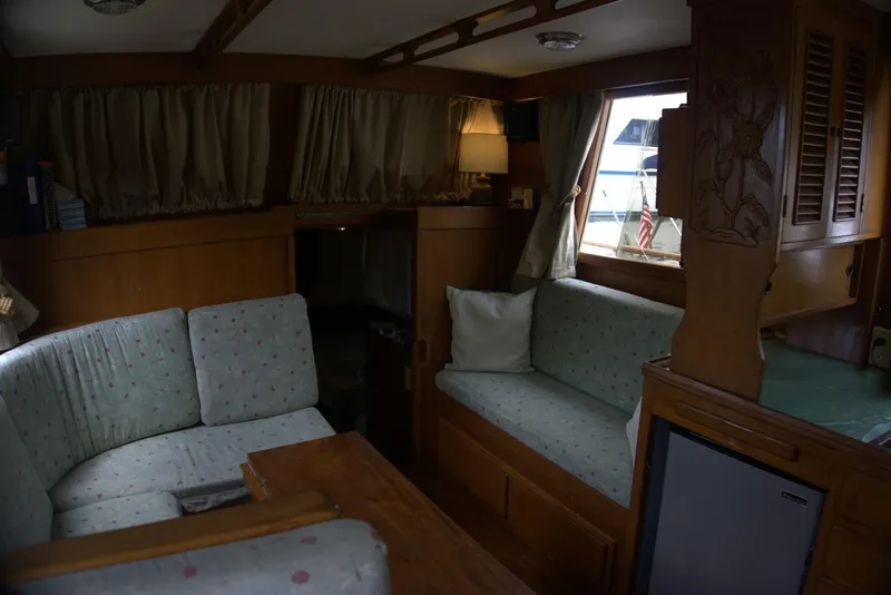 Slide: The Image of Cozy interior of 1991 Marine Trader 34 Double Cabin with wooden furnishings and cushioned seating. - 72
