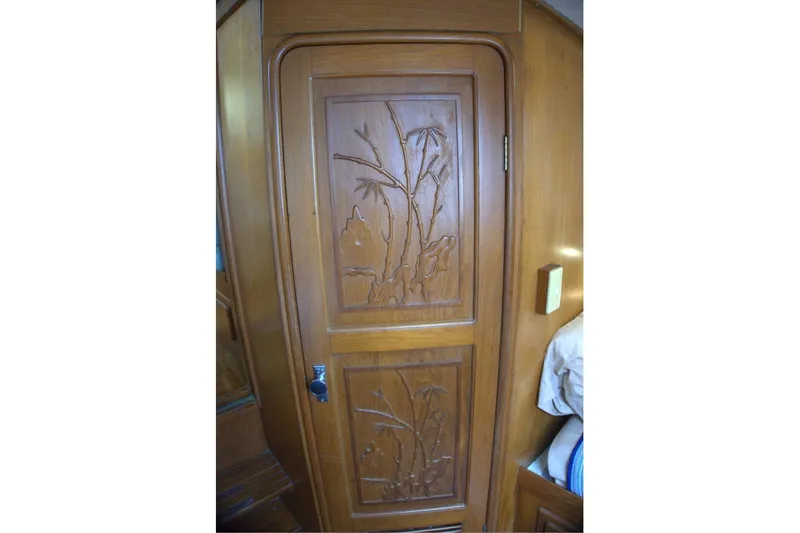 Slide: The Image of Wooden door with intricate carvings inside a 1991 Marine Trader 34 Double Cabin boat. - 74