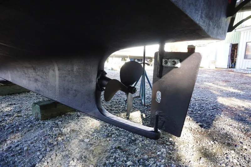 Slide: The Image of Marine Trader 34 Double Cabin 1991 propeller and rudder on gravel surface. - 77