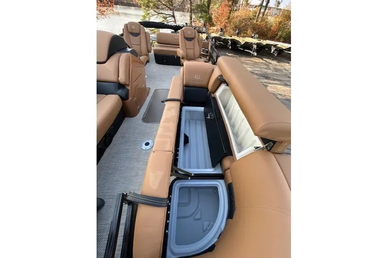Slide: The Image of 2025 Regency 230 LE3 Sport boat interior with tan seating and storage compartments. - 10