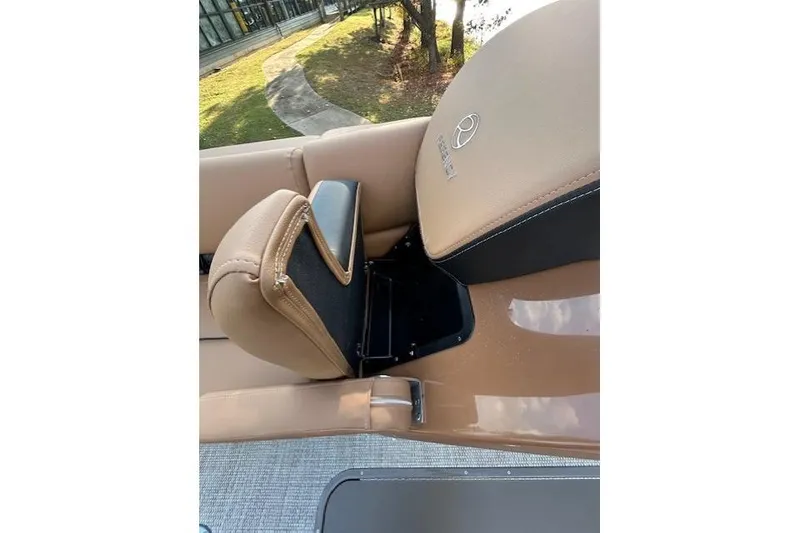 Slide: The Image of 2025 Regency 230 LE3 Sport boat seat with tan upholstery and logo detail. - 12