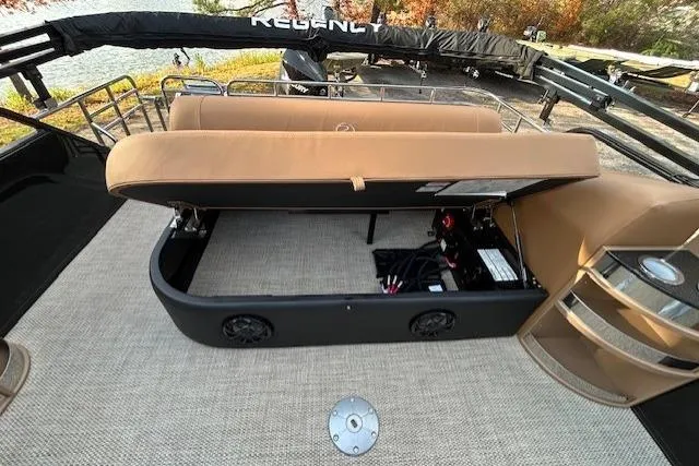 Slide: The Image of 2025 Regency 230 LE3 Sport boat interior with open storage compartment and seating. - 14