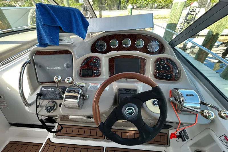 Slide: The Image of Cockpit of 2006 Sea Ray 320 Sundancer with Raymarine navigation system and wooden steering wheel. - 12