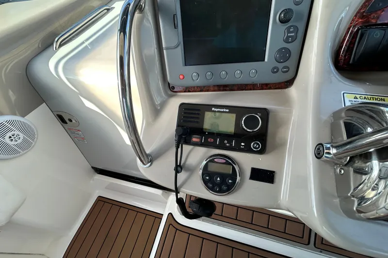 Slide: The Image of 2006 Sea Ray 320 Sundancer helm with navigation controls and Raymarine equipment. - 17
