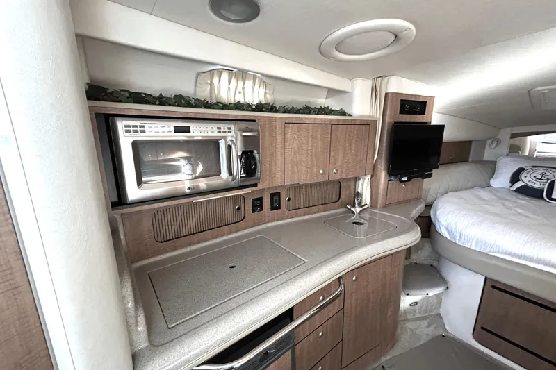 Slide: The Image of Interior of 2006 Sea Ray 320 Sundancer with kitchenette and cozy sleeping area. - 23