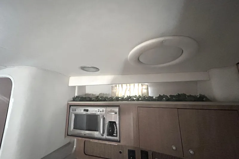 Slide: The Image of Interior of 2006 Sea Ray 320 Sundancer with microwave and decorative greenery. - 32