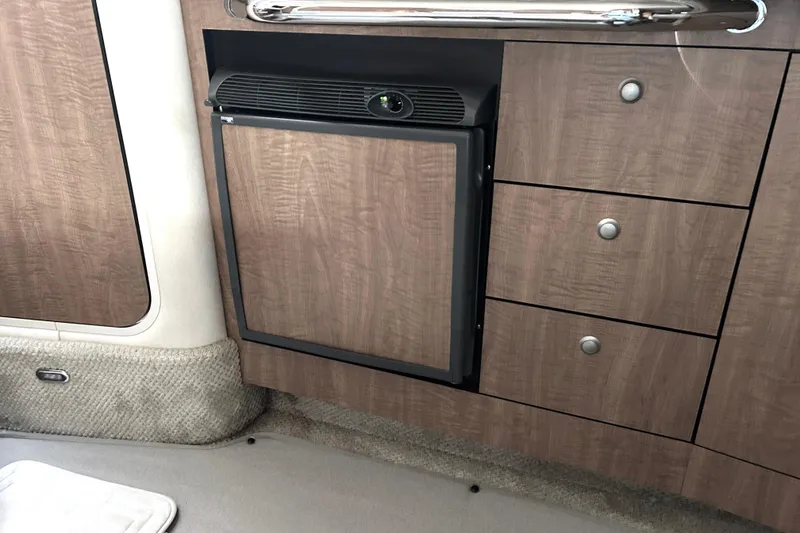 Slide: The Image of Interior of 2006 Sea Ray 320 Sundancer with wood cabinetry and compact fridge. - 35