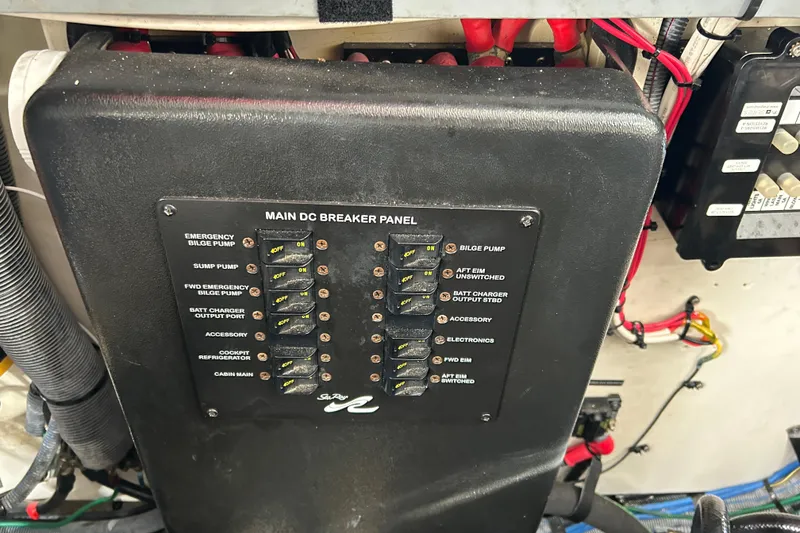 Slide: The Image of Main DC breaker panel on 2006 Sea Ray 320 Sundancer boat, showing various switches and wiring. - 52