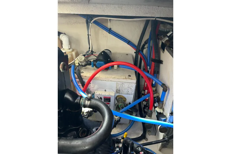 Slide: The Image of Engine compartment of 2006 Sea Ray 320 Sundancer with visible hoses and components. - 55
