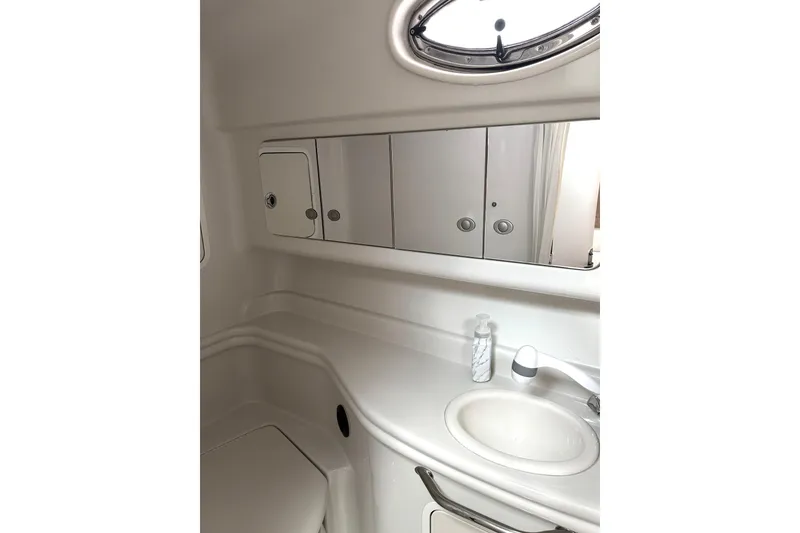 Slide: The Image of 2006 Sea Ray 320 Sundancer bathroom with sink, mirror, and storage cabinets. - 67