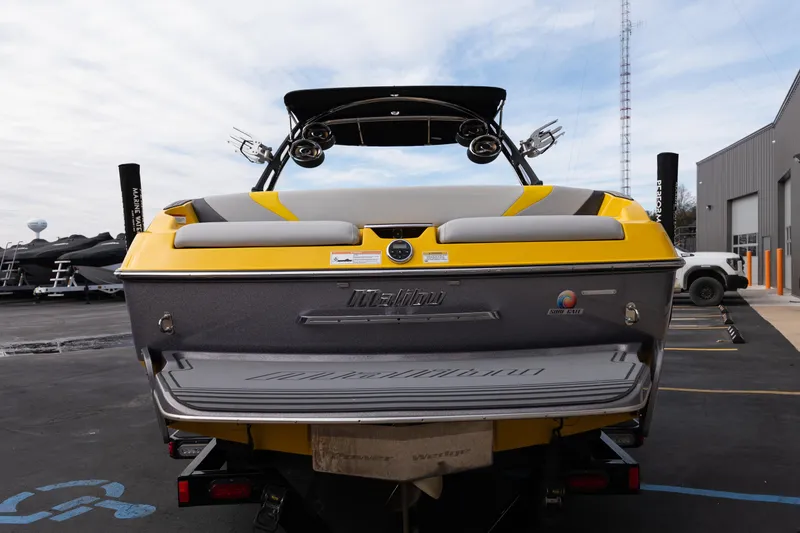 Slide: The Image of 2014 Malibu Wakesetter 24 MXZ boat, yellow and gray, parked at a marina. - 5