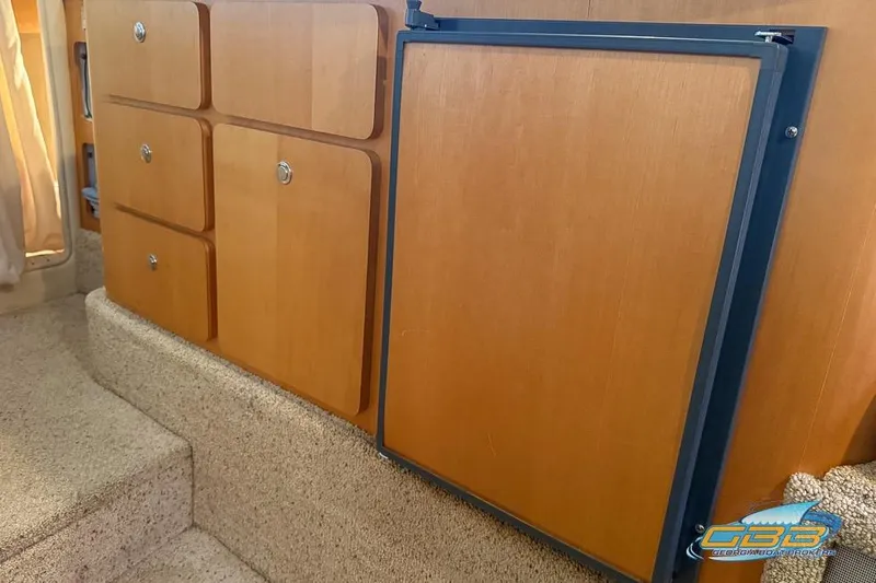 Slide: The Image of 2001 Chris-Craft 26 Constellation interior with wooden cabinetry and carpeted steps. - 13