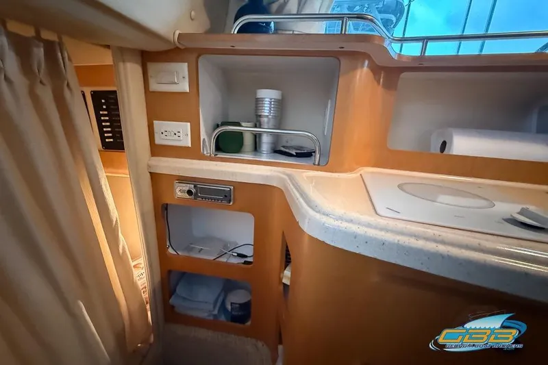 Slide: The Image of Interior of 2001 Chris-Craft 26 Constellation boat, featuring kitchenette and storage areas. - 22