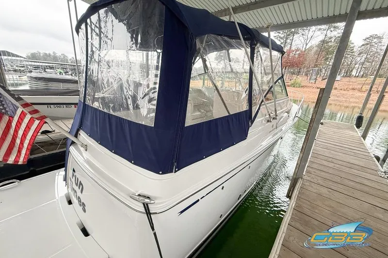 Slide: The Image of 2001 Chris-Craft 26 Constellation boat docked with blue canopy and American flag. - 3