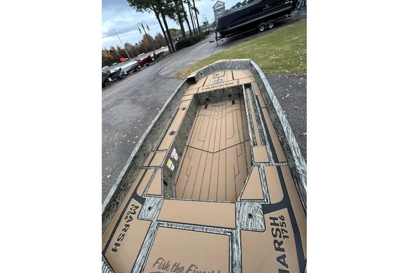 Slide: The Image of 2026 Tracker Grizzly 1756 T Marsh boat with custom deck design, parked outdoors. - 3