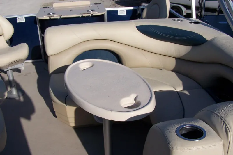 Slide: The Image of 2019 Sylvan 8520 Mirage F-n-C pontoon boat interior with beige seating and table. - 6
