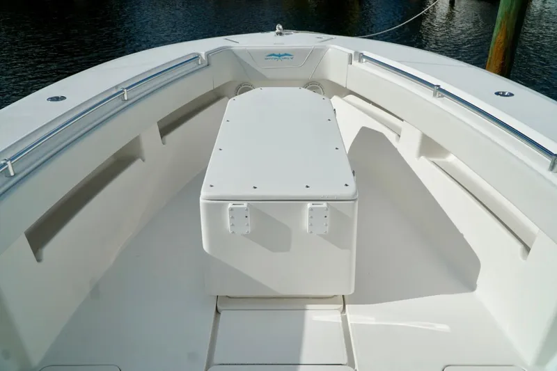 Slide: The Image of Invincible boat deck with seating and storage, docked on calm water. - 13