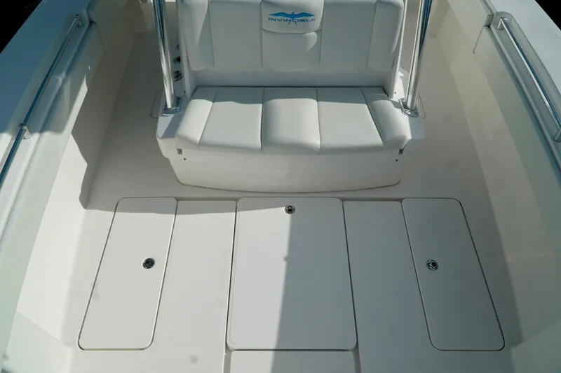 Slide: The Image of Invincible boat interior with white cushioned seating and storage compartments. - 17