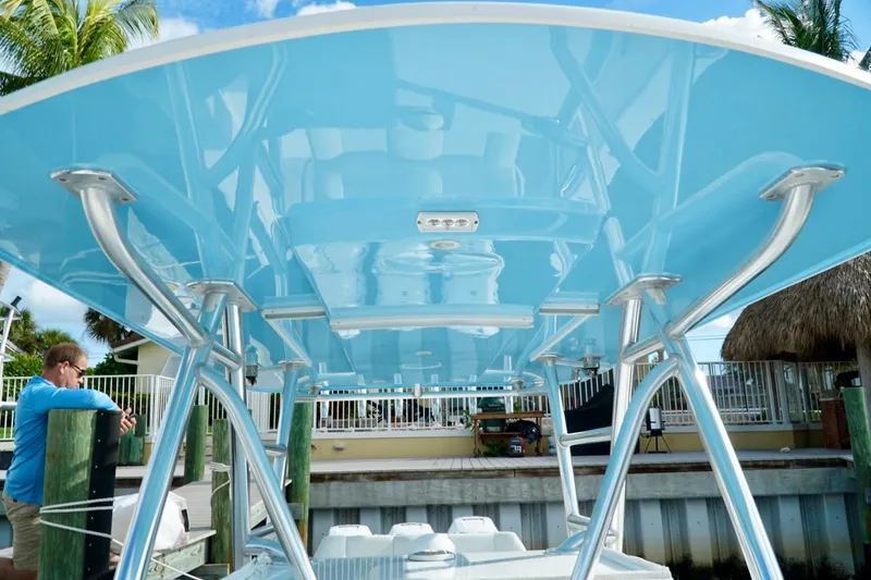 Slide: The Image of Underneath view of Invincible boat's blue canopy with metal supports at a dock. - 20
