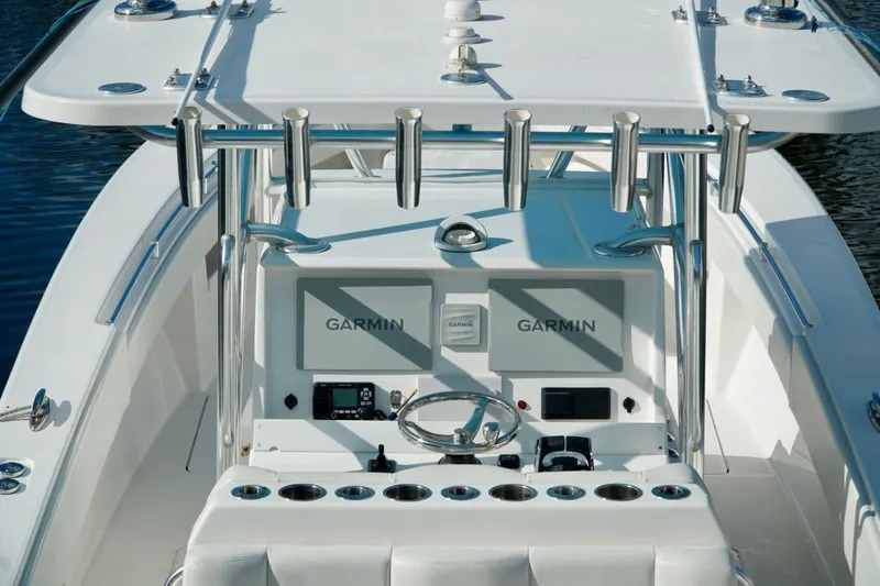 Slide: The Image of Invincible boat helm with Garmin electronics, rod holders, and steering wheel. - 30