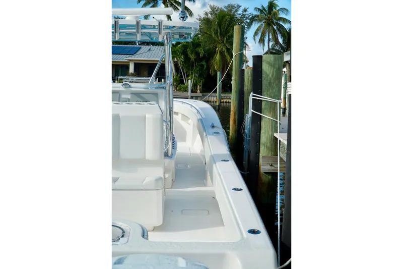 Slide: The Image of Invincible boat docked by palm trees, showcasing sleek white deck design. - 43