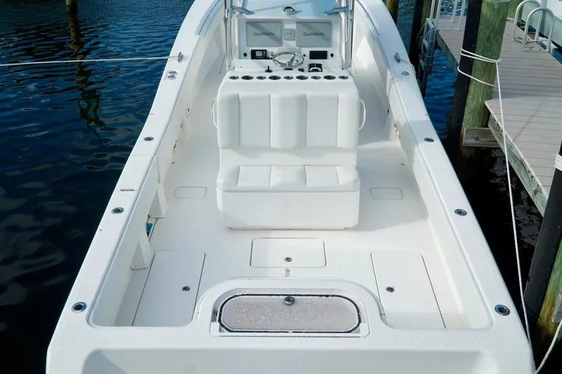 Slide: The Image of Invincible boat interior with seating and Garmin navigation system, docked by the water. - 44