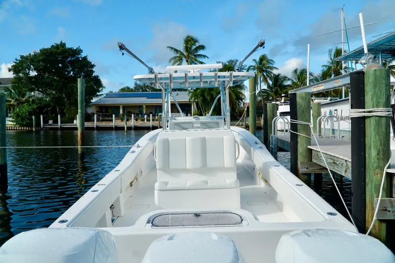 Slide: The Image of Invincible boat docked in a marina with palm trees and clear skies. - 45