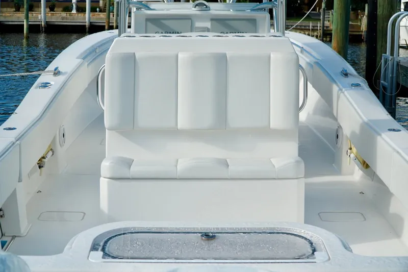 Slide: The Image of White Invincible boat interior with cushioned seating and water view. - 48