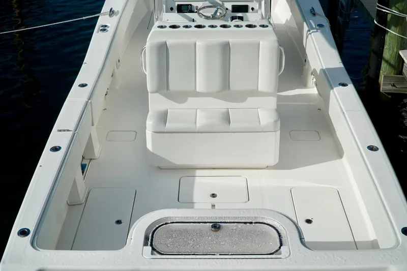Slide: The Image of Invincible boat interior with white seating and storage compartments. - 49