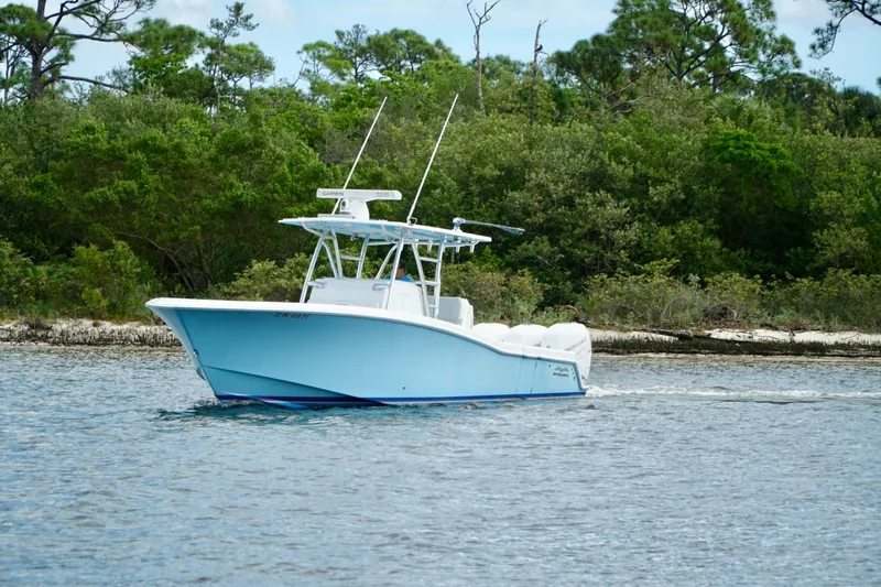 Slide: The Image of Invincible boat cruising on a calm lake with lush green forest background. - 5