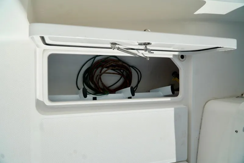 Slide: The Image of Open storage compartment on Invincible boat with coiled ropes inside. - 62