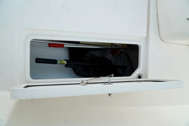 Slide: The Image of Open storage compartment on Invincible boat with fishing gear inside. - 63