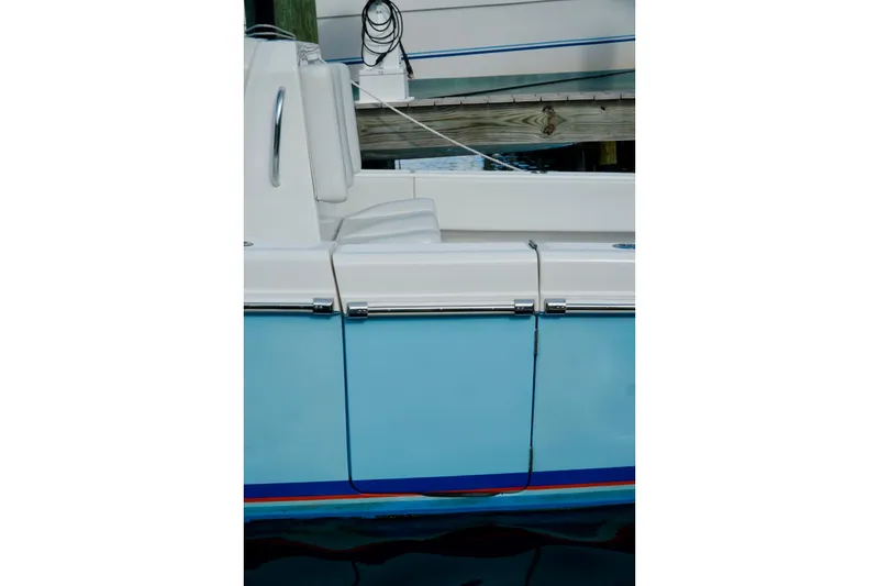 Slide: The Image of Side view of an Invincible boat docked, featuring a sleek blue and white design. - 65