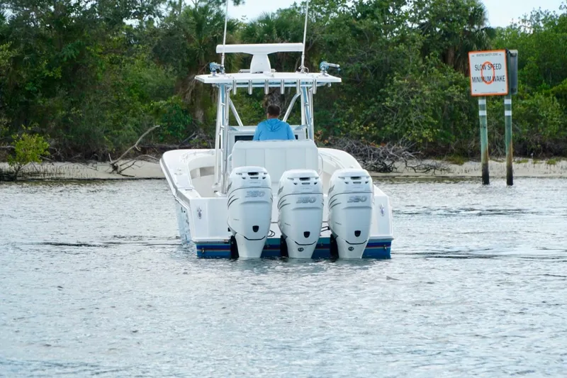 Slide: The Image of Invincible boat with triple engines navigating near a "Slow Speed" sign in calm waters. - 7