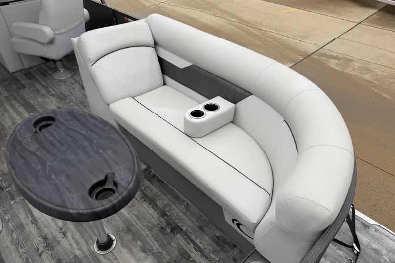 Slide: The Image of 2019 Crest I SLRC boat interior with gray seating and table, featuring cup holders. - 4