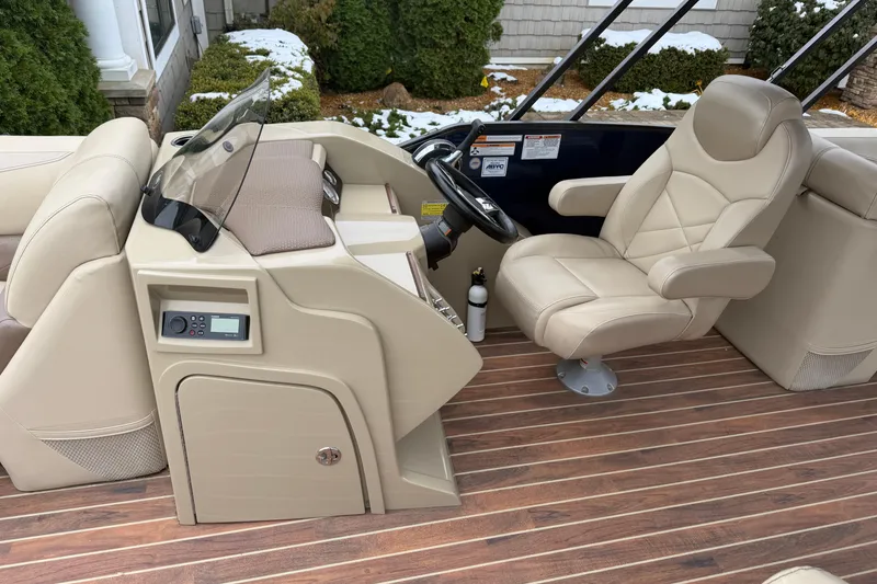 Slide: The Image of 2017 Crest 230SL Classic boat interior with beige captain's chair and wooden flooring. - 8