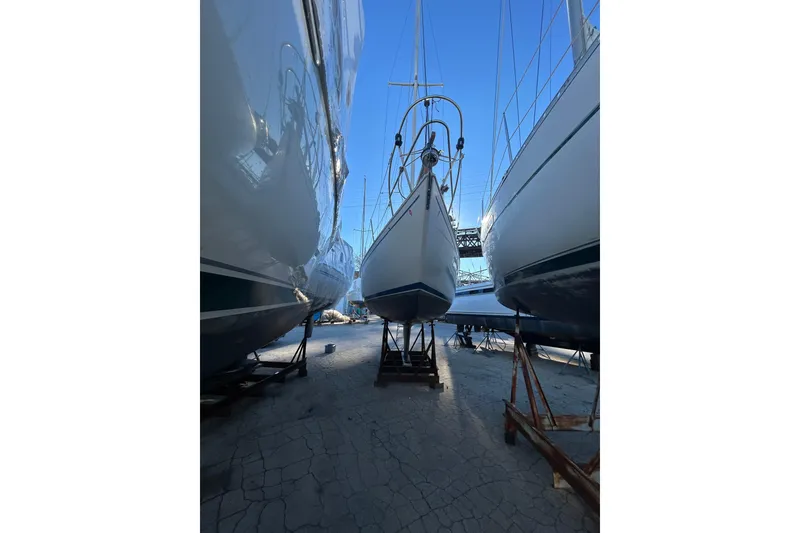 Slide: The Image of 1982 Sabre 30 sailboat on stands in a boatyard, surrounded by other vessels. - 2